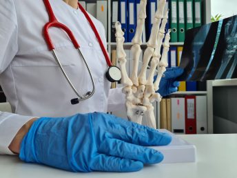 Doctor holds in hands x-ray of the hand and model of skeleton of hands. Medical care for skeletal bone examination or physical test for cancer and arthritis