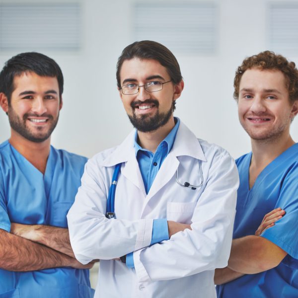 Portrait of three clinicians in uniform looking at camera
